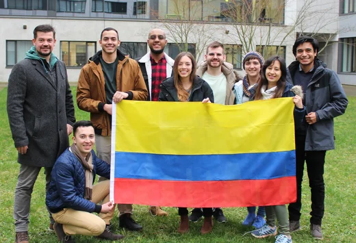 Double Degree Studierende aus Kolumbien im Innenhof des ID-Gebäudes mit kolumbianischer Flagge im Februar 2022. (© RUB/Zeitel)