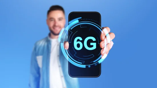 Männerhand zeigt Telefonbildschirm mit leuchtendem 6G-Symbol, großformatiger Kopierraumhintergrund. Display mit digitalem Hologramm der Internetverbindung und futuristischer Technologie.