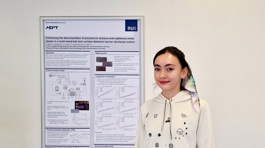 Bachelorstudentin Arisa Bodnar steht vor dem Award-Poster