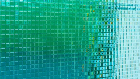 Mosaikwand mit Spiegelung, grün-blaue Optik.