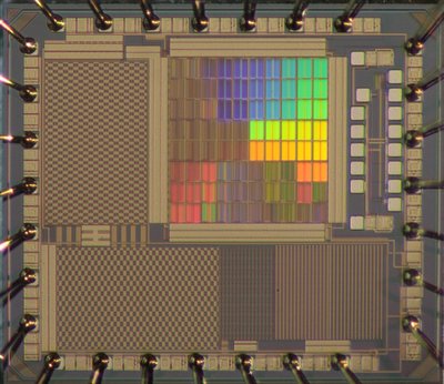 Zu sehen ist ein Testchips mit optisch wirksamen integrierten Strukturen, die regenbogenfarben schimmern. (© Fakultät ETIT/Archiv/Lehrstuhl AIS)