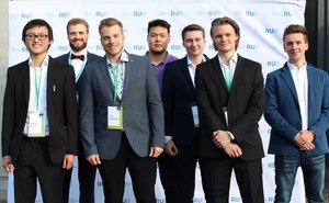 Eine Gruppe von Absolventen nach der offiziellen Übergabe vor der Fotowand im Freien vor dem Audimax (Foto:RUB/Zeitel)