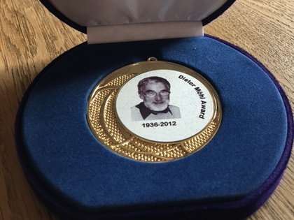 Zu sehen ist eine gold-weiße Medaille mit einem Portrait von Dieter Möhl. Diese Medaille wurde als Award an Dr. Fritz Caspers verliehen. Die Medaille liegt in einer blauen Schatulle. © privat/Caspers