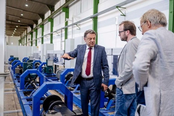 Constantinos Sourkounis (links) zeigt der Delegation des Landtages die Versuchsstände im Smart Windpark Laoratory.